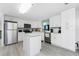Updated kitchen boasts white cabinets, stainless steel appliances, an island, and sleek countertops at 6293 Sparrow Ln, Englewood, FL 34224