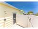 Side-view image displaying an outdoor shower and back entrance for a yellow home at 6293 Sparrow Ln, Englewood, FL 34224