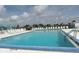 Large outdoor pool with lots of deck chairs, and a beautiful blue sky and clouds overhead at 6293 Sparrow Ln, Englewood, FL 34224