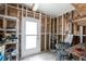 Bright storage room with a white door, framed walls, shelves, tools, and a desk at 6293 Sparrow Ln, Englewood, FL 34224