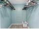 Light blue walk-in closet complete with hanging racks, a folding drying rack, and a clean, white laundry basket at 6293 Sparrow Ln, Englewood, FL 34224