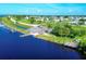 Aerial view of community boat ramp with a parking area and wooden docks for fishing on a sunny day at 7337 Desant Ln, Port Charlotte, FL 33981