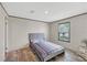 Bedroom with hardwood floors, window, and a bed with a blue tufted headboard at 7337 Desant Ln, Port Charlotte, FL 33981
