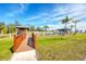 View of community space with well-maintained lawn and gazebo area with a bridge pathway entrance on a sunny day at 7337 Desant Ln, Port Charlotte, FL 33981