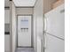 Hallway with white appliances and a white door with glass and white molding at 7337 Desant Ln, Port Charlotte, FL 33981