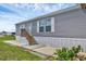Charming home with a tidy gray exterior and wooden steps to the front door at 7337 Desant Ln, Port Charlotte, FL 33981