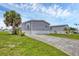 The home features well-maintained lawns, a concrete driveway, and tropical landscaping at 7337 Desant Ln, Port Charlotte, FL 33981