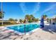 Inviting outdoor pool with clear blue water, surrounded by seating, and beautiful tropical landscaping at 7337 Desant Ln, Port Charlotte, FL 33981