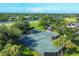 Aerial view of community tennis courts surrounded by verdant landscaping and trees near the water at 7337 Desant Ln, Port Charlotte, FL 33981