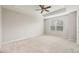 Bright bedroom featuring neutral-toned walls, a ceiling fan, and a large window offering natural light at 8228 Villa Grande Ct, Sarasota, FL 34243