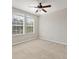 This bedroom features two windows, a ceiling fan, light-colored carpet, and light gray walls at 8228 Villa Grande Ct, Sarasota, FL 34243