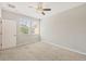 Bright bedroom features a ceiling fan, two large windows, and light-colored carpet at 8228 Villa Grande Ct, Sarasota, FL 34243