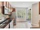 Modern kitchen with stainless steel appliances, tile backsplash, hardwood cabinets, and views of the backyard at 8228 Villa Grande Ct, Sarasota, FL 34243