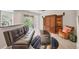 Comfortable living room featuring a futon couch, hardwood floors, a media center, and sliding door access to the patio at 8228 Villa Grande Ct, Sarasota, FL 34243