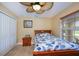 Comfortable bedroom features a ceiling fan, natural light, and tile floors at 9325 Crugar Ter, Englewood, FL 34224