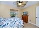 Comfortable bedroom features a ceiling fan, natural light, and tile floors at 9325 Crugar Ter, Englewood, FL 34224