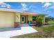 Welcoming front porch with stone accents, seating, and tropical landscaping at 9325 Crugar Ter, Englewood, FL 34224