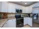 Updated kitchen showcases modern stainless steel appliances and sleek white cabinetry at 9325 Crugar Ter, Englewood, FL 34224