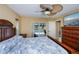 Bright primary bedroom offers view of the pool, tile floors, fan, and closet at 9325 Crugar Ter, Englewood, FL 34224