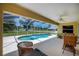 Inviting screened-in pool area with comfortable wicker seating and views of the well-maintained backyard at 9325 Crugar Ter, Englewood, FL 34224