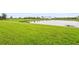 Serene backyard view showcasing a well-maintained lawn and a peaceful pond at 10258 Morning Mist Ln, Sarasota, FL 34241