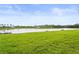 Picturesque backyard view featuring lush green grass and a tranquil lake at 10258 Morning Mist Ln, Sarasota, FL 34241