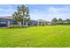 Expansive backyard featuring a well-maintained lawn, screened-in patios, and lush landscaping at 10258 Morning Mist Ln, Sarasota, FL 34241
