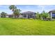Beautiful backyard featuring a spacious lawn, a screened-in patio, and vibrant flowering plants at 10258 Morning Mist Ln, Sarasota, FL 34241