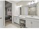 Bathroom featuring dual sinks, vanity area, and a separate glass-enclosed shower, adjacent to bedroom at 10258 Morning Mist Ln, Sarasota, FL 34241