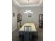Cozy dining room with tray ceiling, chandelier lighting, and display cabinets at 10258 Morning Mist Ln, Sarasota, FL 34241