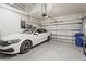A clean, well-organized garage featuring an epoxy floor, overhead storage, and a parked car at 10258 Morning Mist Ln, Sarasota, FL 34241