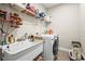 Functional laundry room featuring a modern washer and utility sink with storage at 10258 Morning Mist Ln, Sarasota, FL 34241