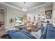 Cozy living room with a large blue sofa, flat screen tv, and adjacent dining and kitchen areas at 10258 Morning Mist Ln, Sarasota, FL 34241