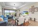 Bright living room with a sectional sofa, view of lake, stylish rug and tile flooring at 10258 Morning Mist Ln, Sarasota, FL 34241