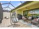 Enclosed patio with stylish seating, a hanging chair, and serene water views at 10258 Morning Mist Ln, Sarasota, FL 34241