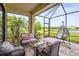 Relaxing screened-in patio with comfortable seating and a scenic lake view at 10258 Morning Mist Ln, Sarasota, FL 34241