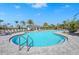 Community pool featuring accessible entry, lounge chairs, and lush tropical landscaping at 10258 Morning Mist Ln, Sarasota, FL 34241