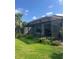 Relaxing screened-in porch with views of the landscaped backyard and mature palm trees at 10258 Morning Mist Ln, Sarasota, FL 34241