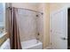 Clean bathroom showcases a white shower/tub combo with neutral tile and bronze shower curtain at 10487 Coquina Ct, Placida, FL 33946