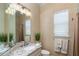 Bright bathroom featuring granite counters, neutral paint, decorative towels, and large mirror at 10487 Coquina Ct, Placida, FL 33946