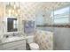 A bathroom featuring stylish wall paper, granite counter tops and a walk-in shower at 10487 Coquina Ct, Placida, FL 33946