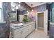 A spacious bathroom with granite counters, decorative wall paper, and a walk in shower at 10487 Coquina Ct, Placida, FL 33946