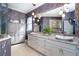 A spacious bathroom with dual sinks, granite counters, and decorative wallpaper at 10487 Coquina Ct, Placida, FL 33946