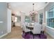 Bright dining room with round table, chandelier, and decorative rug on hardwood floor at 10487 Coquina Ct, Placida, FL 33946