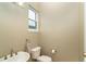 Half-bath features neutral paint, window, sink, toilet and bronze faucet fixture at 10487 Coquina Ct, Placida, FL 33946