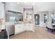 Open kitchen with stainless steel appliances, white cabinets, and seamless transition to living space at 10487 Coquina Ct, Placida, FL 33946