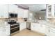 Modern kitchen featuring white cabinets, stainless steel appliances, and light granite countertops at 10487 Coquina Ct, Placida, FL 33946