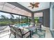 Comfortable screened lanai with ceiling fan, poolside seating, and relaxing views of lush greenery at 10487 Coquina Ct, Placida, FL 33946
