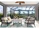 Screened-in patio with comfortable seating, ceiling fan, and views of lush greenery at 10487 Coquina Ct, Placida, FL 33946