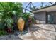 Charming backyard patio with tropical plants, an urn, and peaceful seating at 10487 Coquina Ct, Placida, FL 33946
